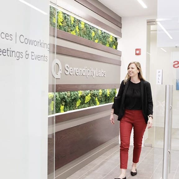 Woman walking into the main entrance of Serendipity Labs.